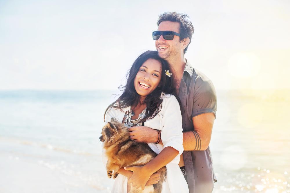 couple smiling on beach | cosmetic dentist newcastle